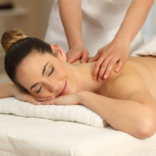 Relaxed woman receiving a back massage in a spa salon